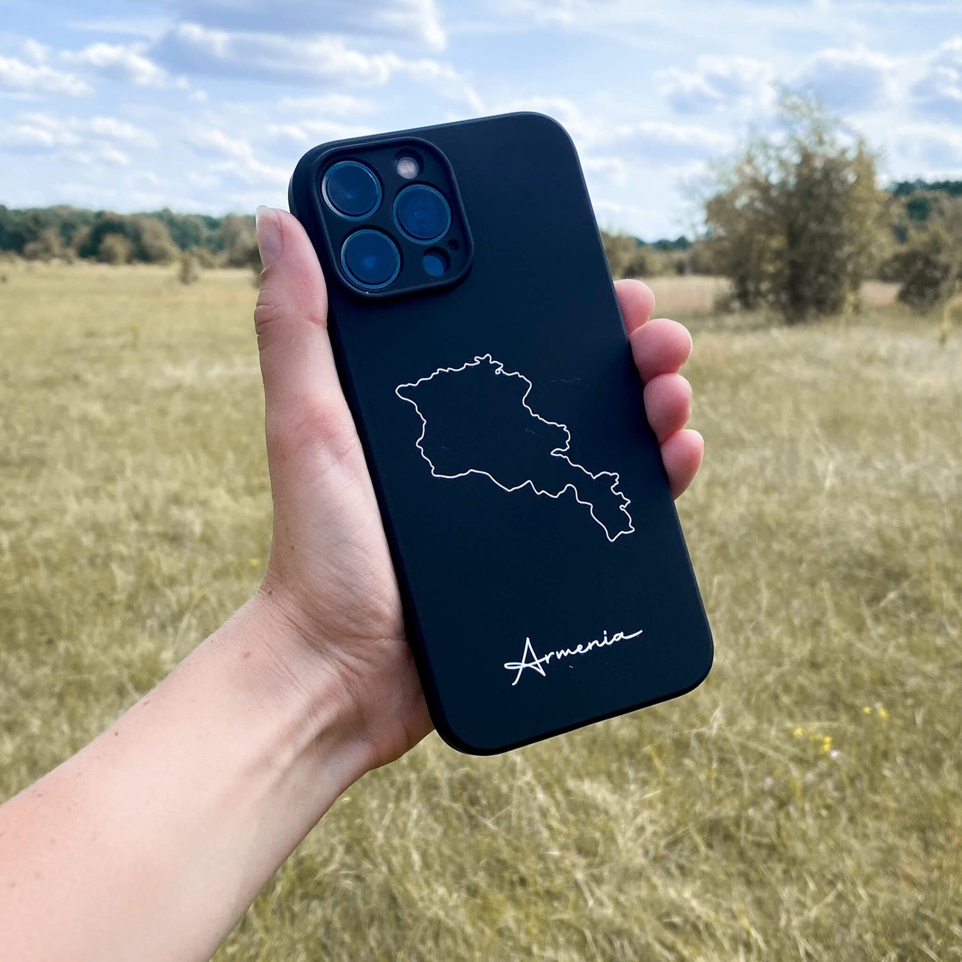 Armenien Handyhülle in der Hand vor einer Wiese