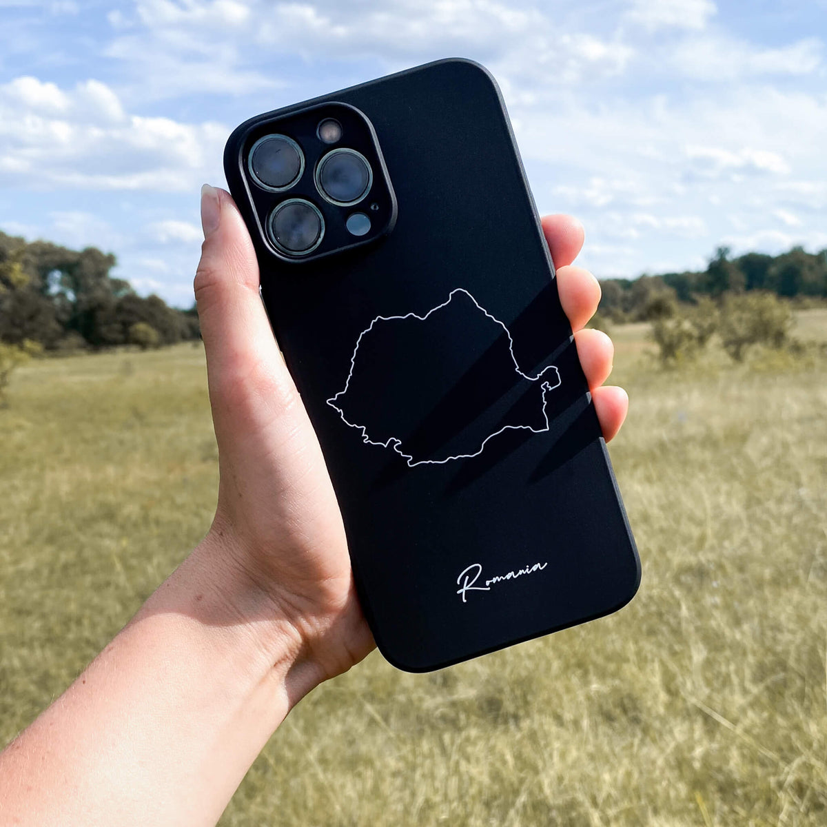 Rumänien Handyhülle in der Hand vor einer Wiese