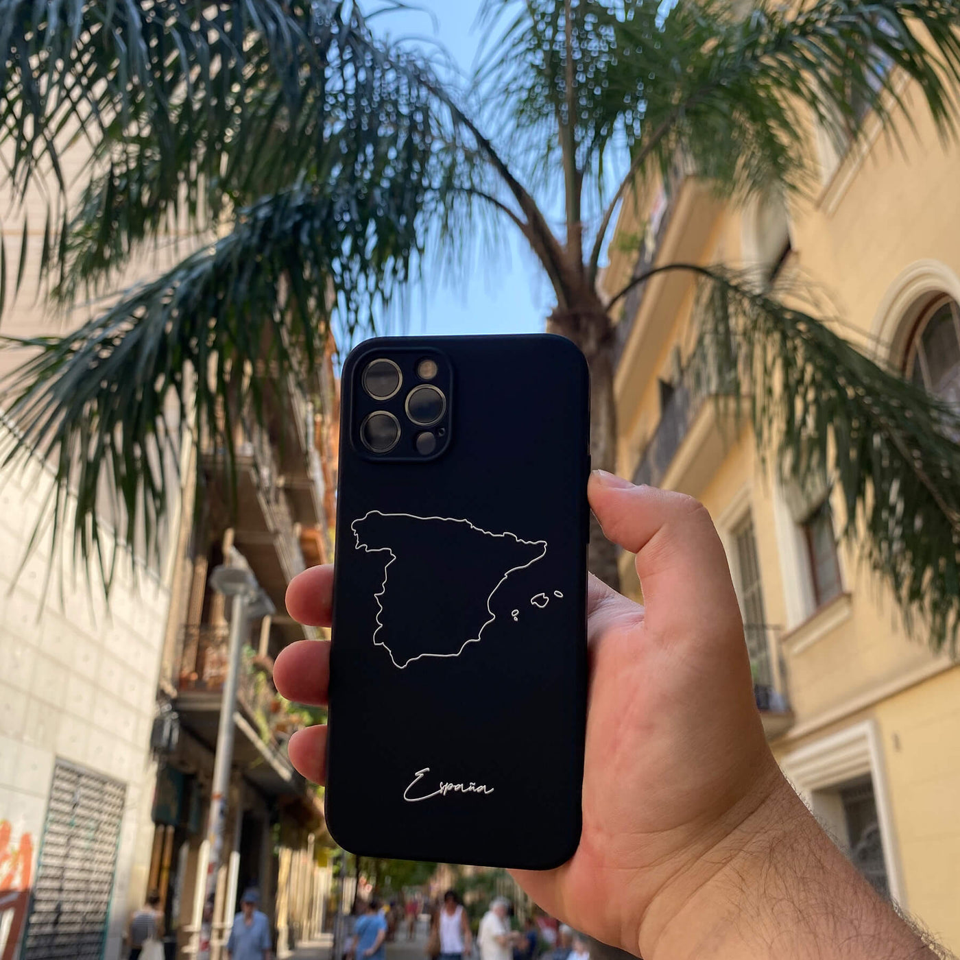 Spanien Handyhülle in der Hand in einer Straße mit Palmen