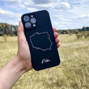 Poland phone case held in the hand in front of a meadow
