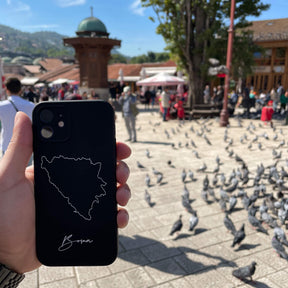 Bosnia phone case held in the hand on an old-town square with pigeons
