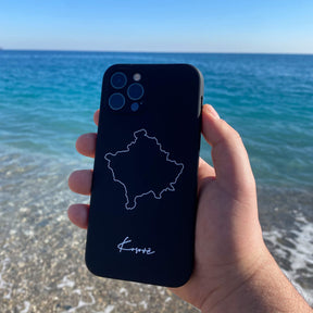 Kosovo Handyhülle in der Hand über klarem Wasser am Strand